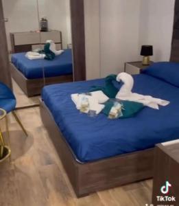 1 dormitorio con 2 camas con sábanas azules y un cisne en B&B Nami, en Palagianello