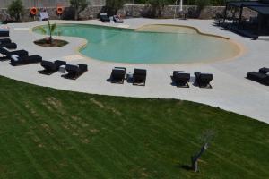 a pool with chaise lounge chairs and a swimming pool at Niki Studios Sea - Front in Petra