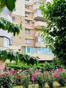 a building with a bunch of flowers in front of it at By The Sea for Family in Mangalia