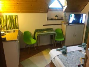 a small kitchen with green chairs and a sink at Balaton Garden in Balatongyörök