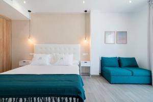 a bedroom with a bed and a blue couch at Nerja VG Hostal Boutique in Nerja