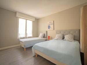 a bedroom with two beds and a window at appartement du Bellay in Sarlat-la-Canéda