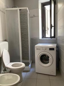 uma casa de banho com um WC e uma máquina de lavar roupa em Casa di Vigata em Licata