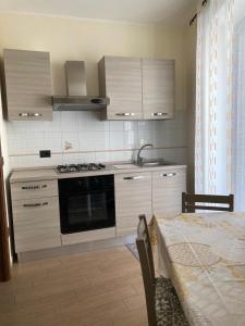 uma cozinha com um fogão, um lavatório e uma mesa em Casa di Vigata em Licata