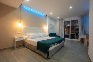 a bedroom with a large bed with a blue light at Nerja VG Hostal Boutique in Nerja
