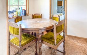 uma mesa de jantar com cadeiras e uma mesa de madeira em 3 Bedroom Lovely Home In Bredaryd em Bredaryd