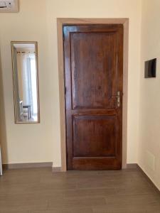 uma porta de madeira num quarto com um espelho em Casa di Vigata em Licata