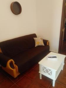 Casas da Saibreira - nº9 في الفاس: غرفة معيشة مع أريكة سوداء وطاولة بيضاء