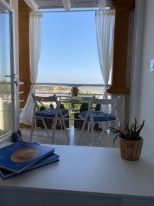 a table and chairs in a room with a balcony at La Savina Ses Platgetes in La Savina