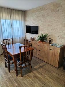 ein Esszimmer mit einem Tisch und Stühlen sowie einem TV in der Unterkunft Lake House in Jurilovca