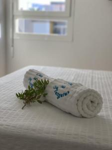 a rolled up towel with a plant on a bed at La Savina Ses Platgetes in La Savina
