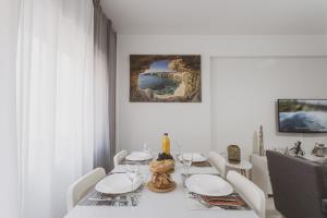 a white dining room with a table and chairs at Best Houses 20 - Lovely Apartament - Peniche in Peniche