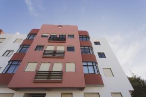 Best Houses 20 - Lovely Apartament - Peniche في بينيش: مبنى وردي طويل مع نوافذ