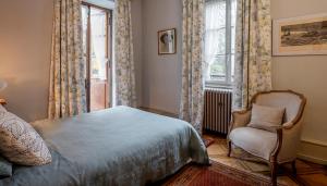 sypialnia z łóżkiem, krzesłem i oknem w obiekcie Hôtel-Résidence La Rubanerie w mieście Schirmeck