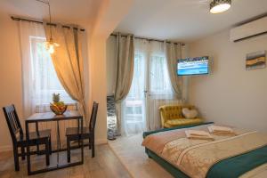 una camera con letto, tavolo e sedia di Wellness Studio D'Or - Exclusive NEW apartment With whirlpool, sauna, sunny terrace, private parking a Poreč (Parenzo)