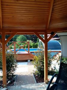 a wooden pergola with a pool in the background at Apartmán Pohoda in Teplý Vrch
