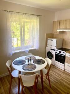 a kitchen with a table and chairs in a room at Apartament Lux in Gołdap