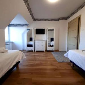 a large bedroom with two beds and two mirrors at Apartament Lux in Gołdap