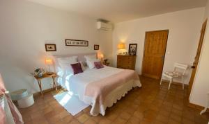 a bedroom with a large white bed in a room at La ferme de gigognan in Avignon