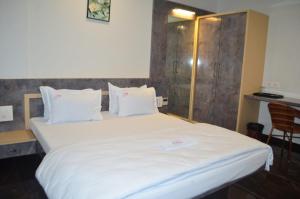 a bedroom with a large bed with white sheets and pillows at Hotel O2 Sangli in Sangli