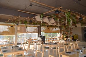 a dining room with tables and chairs and plants at Hotel O2 Sangli in Sāngli