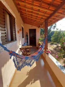 a hammock on the porch of a house at Pousada Cachoeirinha in Baependi