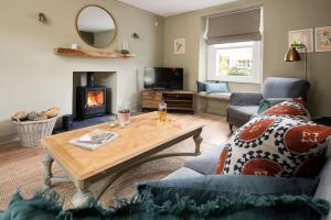 a living room with a coffee table and a fireplace at Campsie Cottage in Ancrum