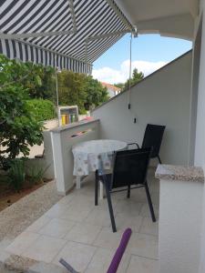 a patio with a table and chairs under a pergola at Apartment Luna in Malinska