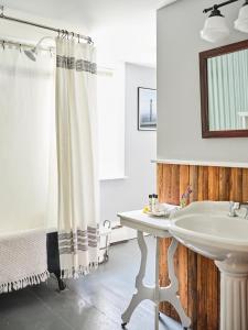 W łazience znajduje się biała umywalka i lustro. w obiekcie Cedar Hill Farm B & B w mieście Essex