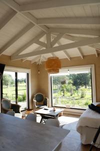 a room with a table and chairs and a large window at Finca Soñada in Colonia del Sacramento