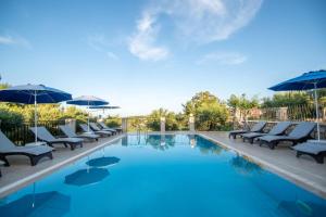 einen Pool mit Liegestühlen und Sonnenschirmen in der Unterkunft Aeolos Zante Villas with Heated Pool in Vasilikos