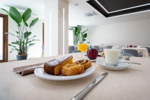 een tafel met een bord brood, koffie en drankjes bij La Terra Dei Sogni Country Hotel in Fiumefreddo di Sicilia