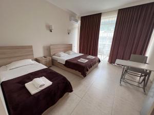 Rúm í herbergi á SUNSHINE Hotel Kvariati