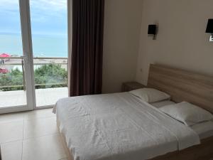 Rúm í herbergi á SUNSHINE Hotel Kvariati