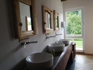 a bathroom with three sinks and two mirrors at Green Camp - Adventure Glamping in Gura Teghii