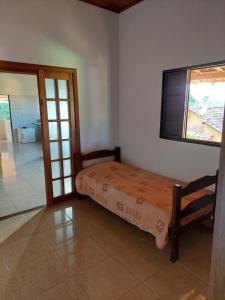 a small bed in a room with a window at Pousada Cachoeirinha in Baependi +55 photos