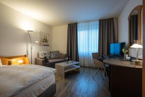 a hotel room with a bed and a desk at Hotel Pfälzer Hof GmbH in Braunschweig