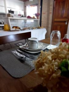 Pousada Cravo e Canela SJ في ساو جواكيم: طاولة مع صحن من الطعام وكأس