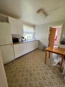 a kitchen with white cabinets and a table in it at Lyngen House in Olderdalen +6 photos