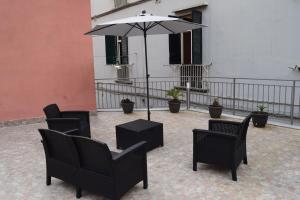 a patio with chairs and a table and an umbrella at Dimora D’alessandro in Naples