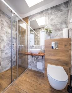a bathroom with a toilet and a sink at Lumi Resort Domki letniskowe z podgrzewanym basenem in Rewal
