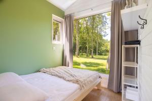 a bedroom with a bed and a large window at Lumi Resort Domki letniskowe z podgrzewanym basenem in Rewal +49 photos