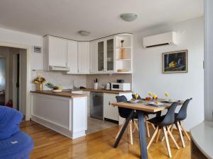 a kitchen with white cabinets and a table and chairs at Apartment Lana in Split