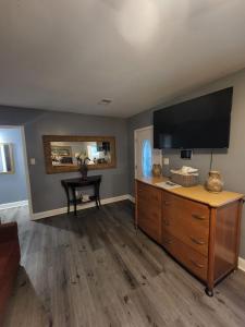 a living room with a television and a wooden dresser at Near Beale Street, 6BR - 3BA 16 BEDS Sleeps up to 37 Guest in Memphis