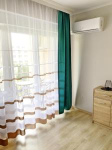 a room with a window with green and white curtains at Szende Apartman in Balatonfüred