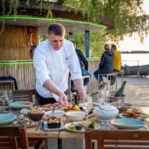 un chef que prepara una mesa con comida. en Delta Boutique & Carmen Silva Resort, en Crisan