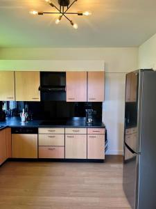 a kitchen with wooden cabinets and a stainless steel refrigerator at R&M in Kortessem