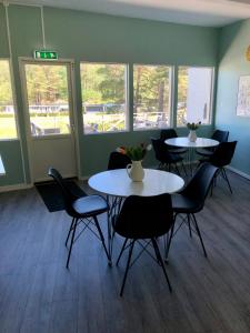 two tables and chairs in a room with windows at Vandrarhem, Hostel in Hällestrand Semesterby in Strömstad