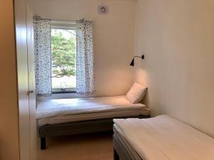Cette petite chambre comprend 2 lits et une fenêtre. dans l'établissement Vandrarhem, Hostel in Hällestrand Semesterby, à Strömstad