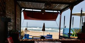 a view of a beach with an umbrella and the ocean at Aftas Beach House in Mirleft